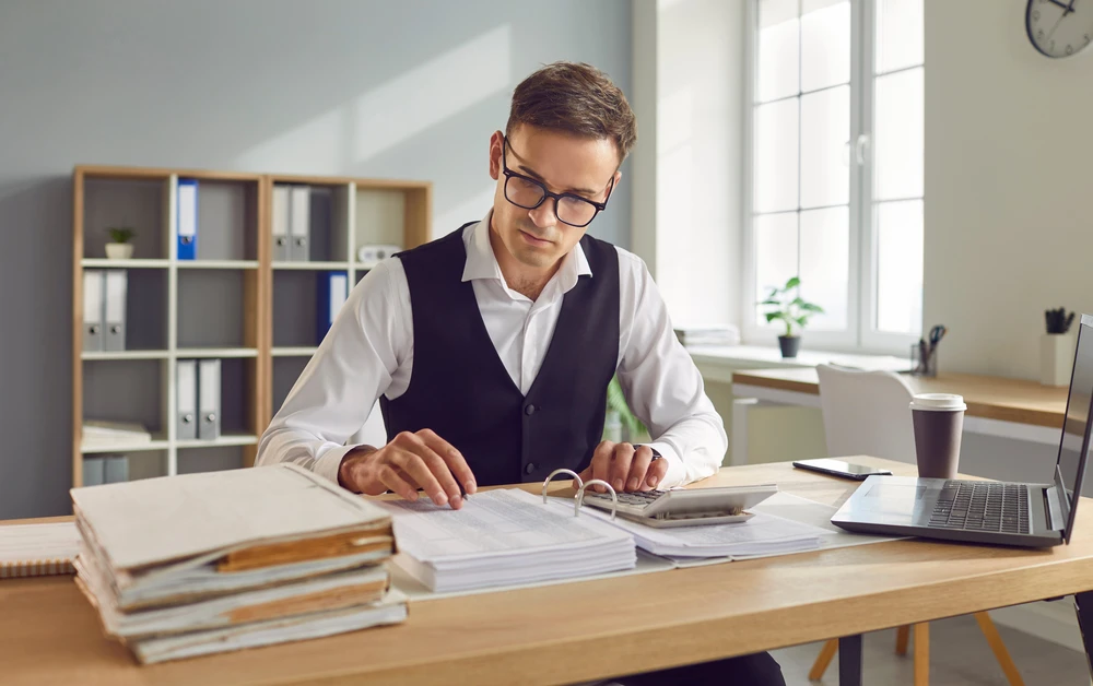 Réunion d'affaires dans bureau moderne avec trois personnes analysant données financières