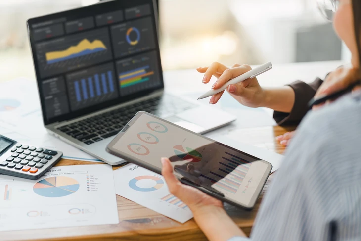 Réunion d'affaires en intérieur avec deux professionnels analysant des documents financiers sur une table