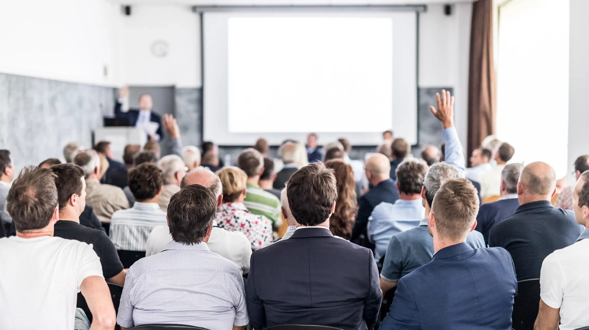 Réunion d'affaires dans salle de conférence moderne avec quatre professionnels en tenue formelle analysant documents autour table rectangulaire